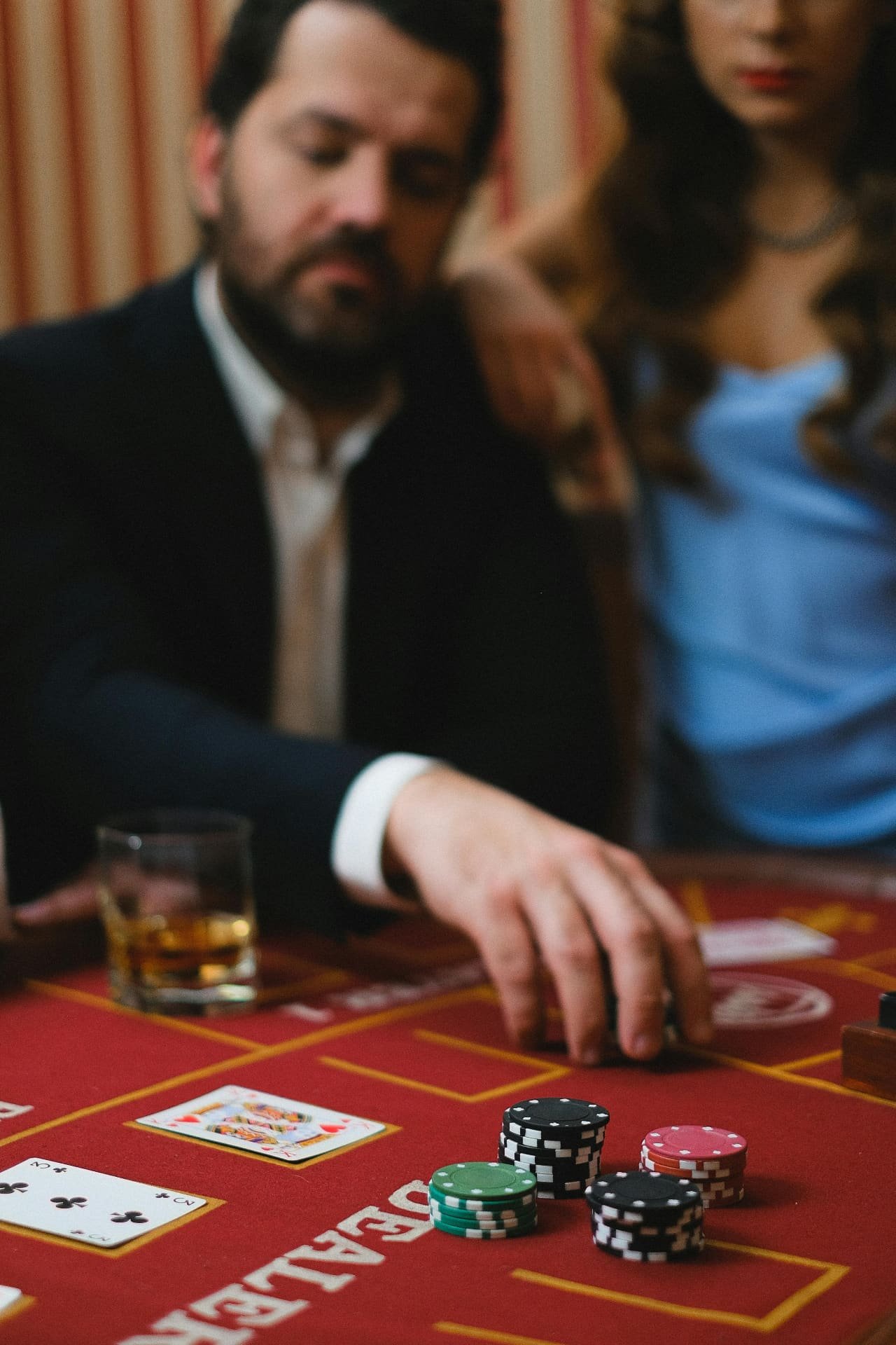 Guest placing bet at red felt card table